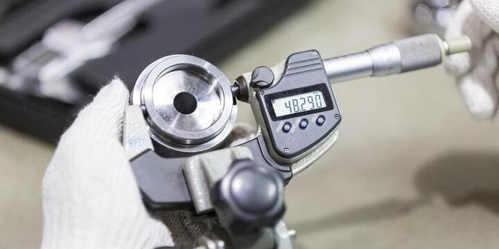 Micrometers and calipers measuring CNC machined aluminum component features