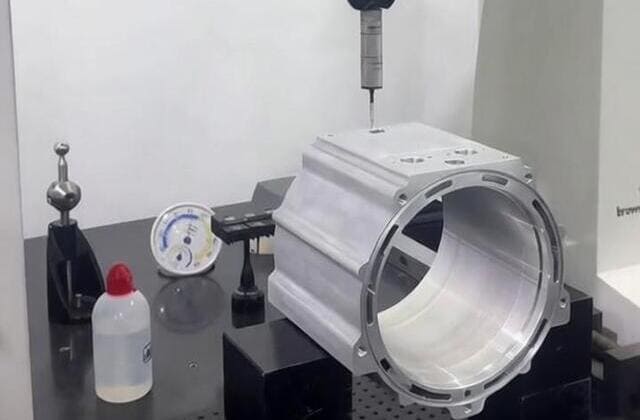 Final inspection of CNC aluminum robotic component using precision measuring tools